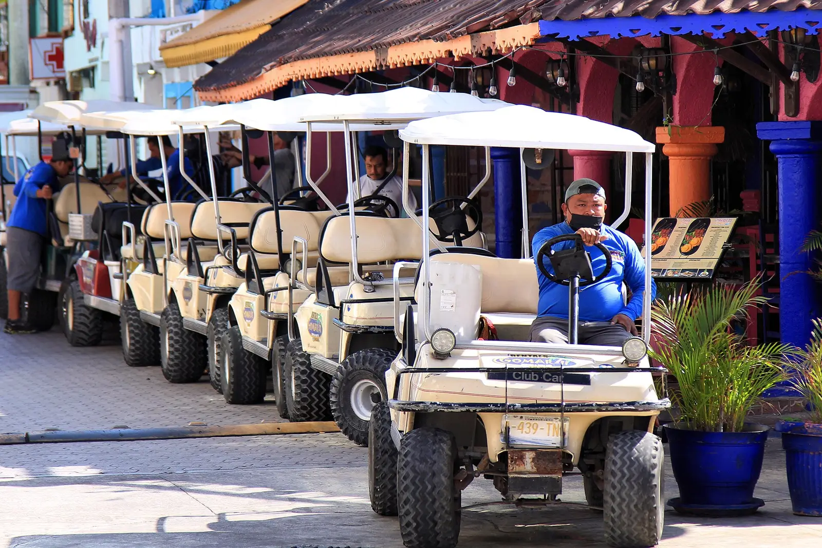 Workers preparing a row of rental golf carts